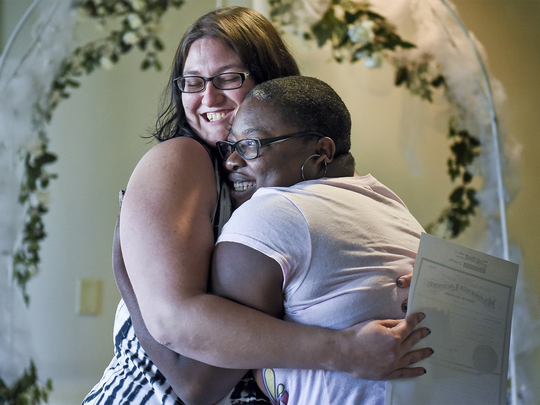 The first same-sex couple to legally wed in El Paso County embrace as Colorado began issuing same-sex marriage licences on Tuesday