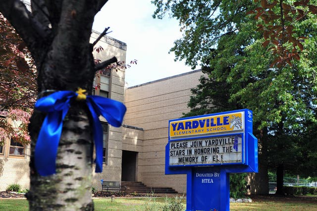 A blue and gold ribbon wrap around a tree in front of Yardville Elementary School in Hamilton Township. The ribbon and sign honored the memory of a preschooler who died on 25 September of enterovirus 68 