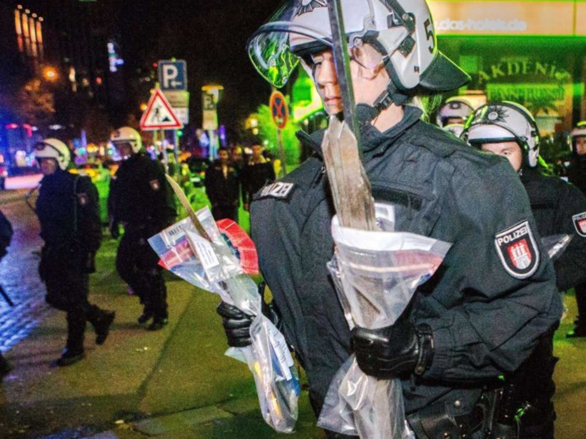 A police officer carries weapons from the scenes in Hamburg