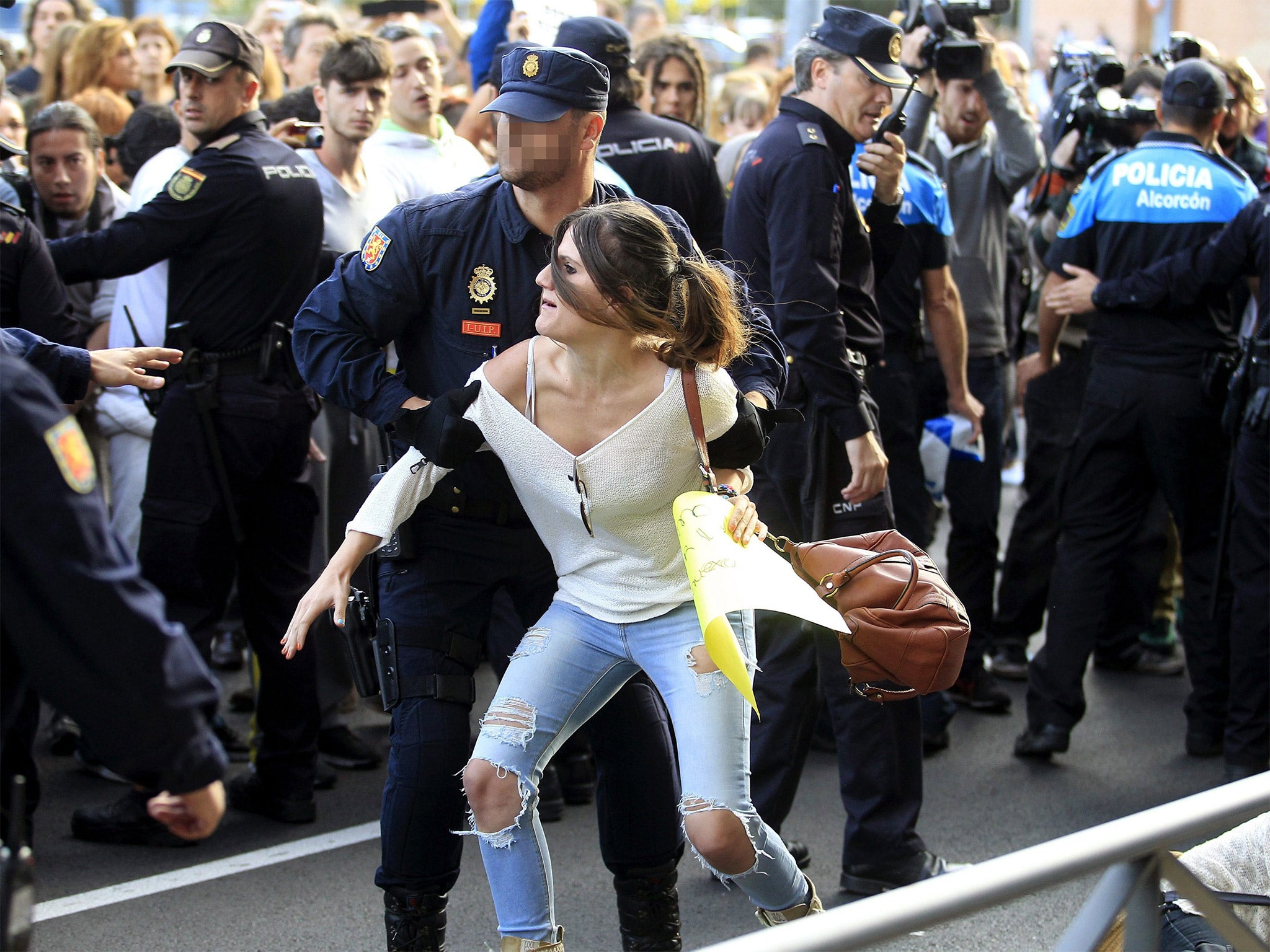 A demonstrator is removed by a policeman near the home of Teresa Romero, in Alcorcon