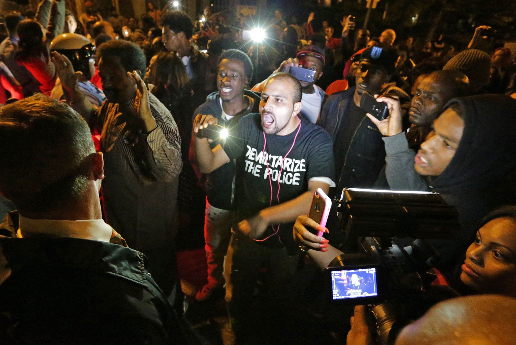 Crowds confront police near the scene in in south St. Louis where a man was fatally shot by an off-duty St. Louis police officer on Wednesday, Oct. 8, 2014