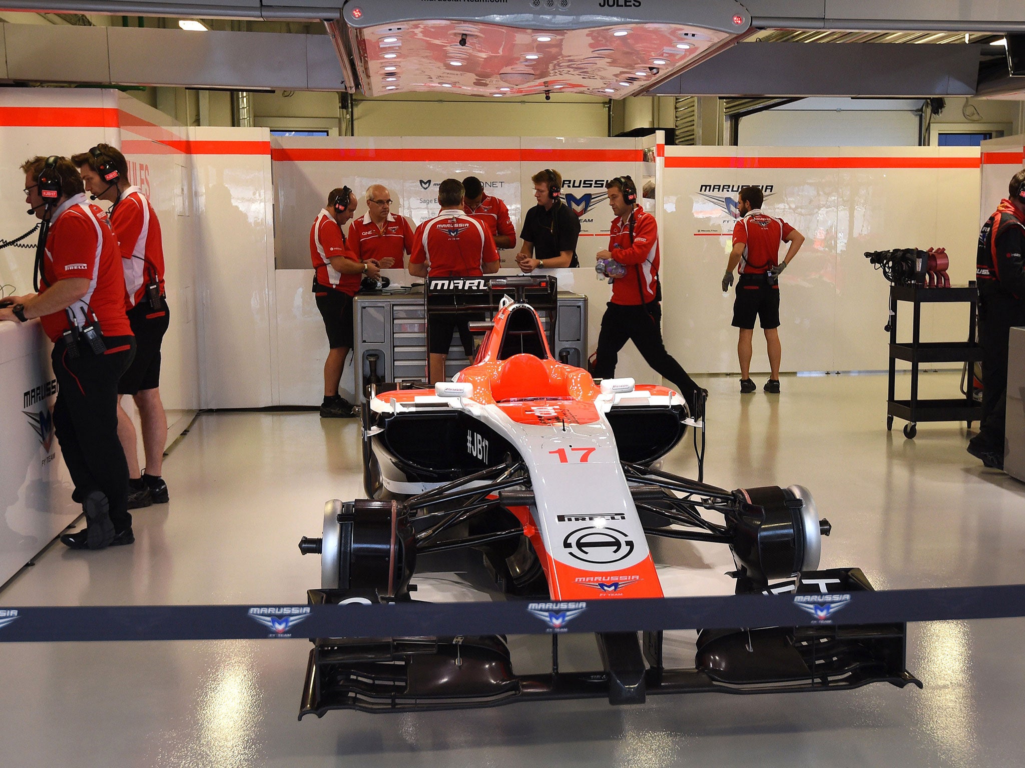 Marussia mechanics and engineers stand behind Jules Bianchi's No 17 car in Sochi