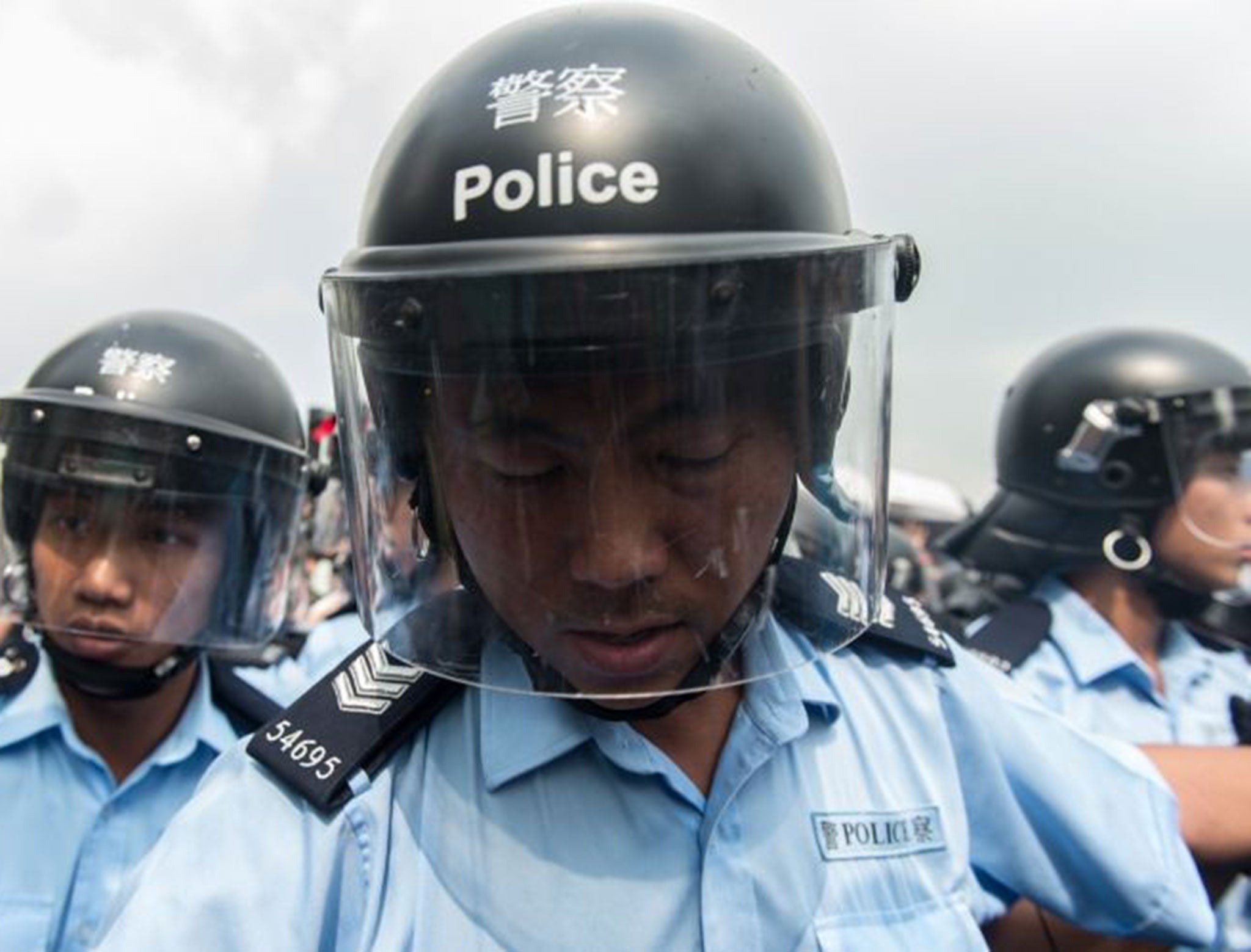 Police form a line to make way for an ambulance as pro-democracy protestors shout slogans outside the government headquarters in Hong Kong on October 3