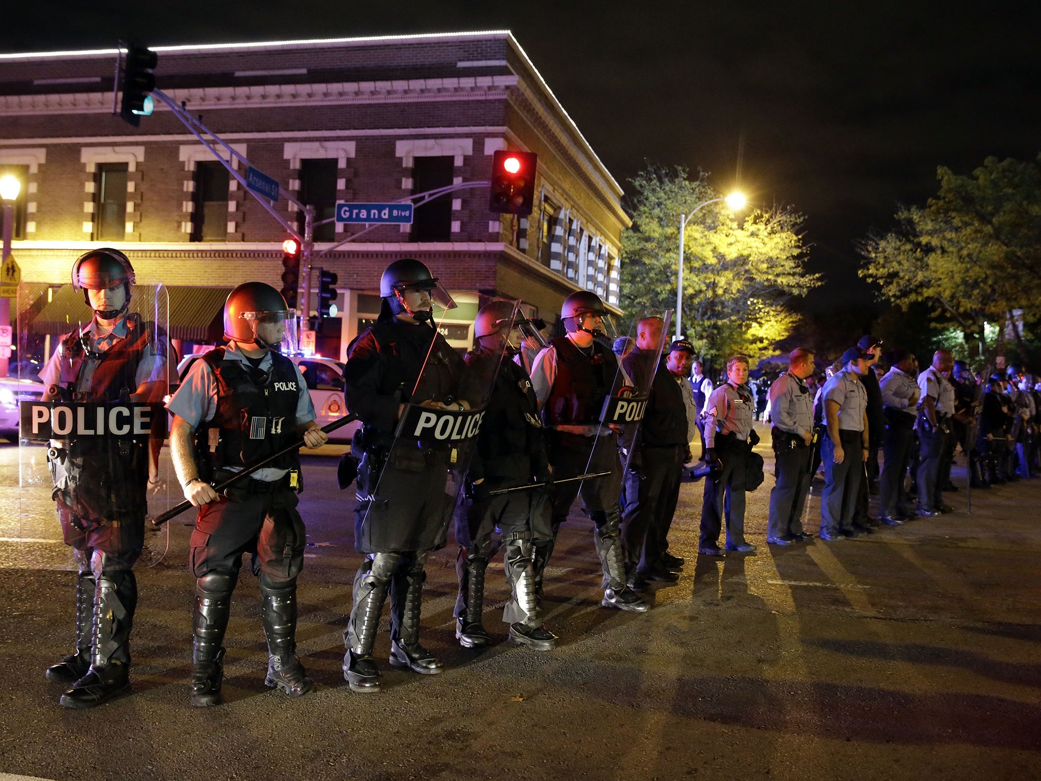 Police wearing riot gear form a line to contain protesters, a day after Vonderrit D. Myers was shot and killed by white, off-duty police officer in St. Louis