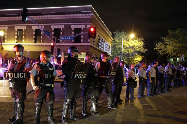 Police wearing riot gear form a line to contain protesters, a day after Vonderrit D. Myers was shot and killed by white, off-duty police officer in St. Louis