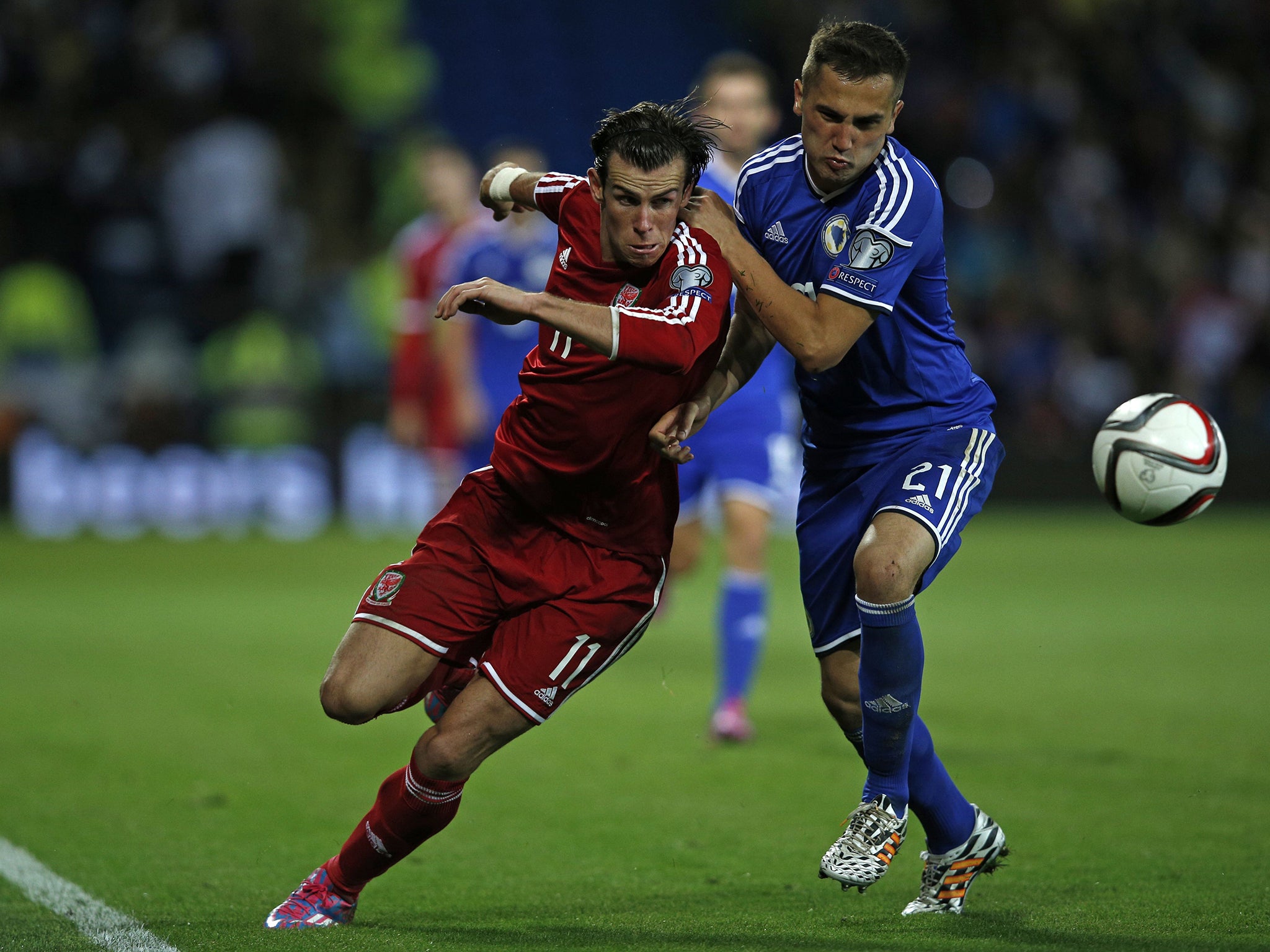 Gareth Bale vies with Bosnia and Herzegovina's midfielder Anel Hadzic