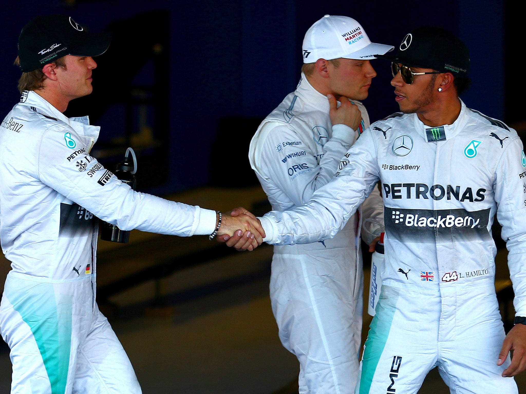 Nico Rosberg shakes hands with Lewis Hamilton after the latter secures pole position