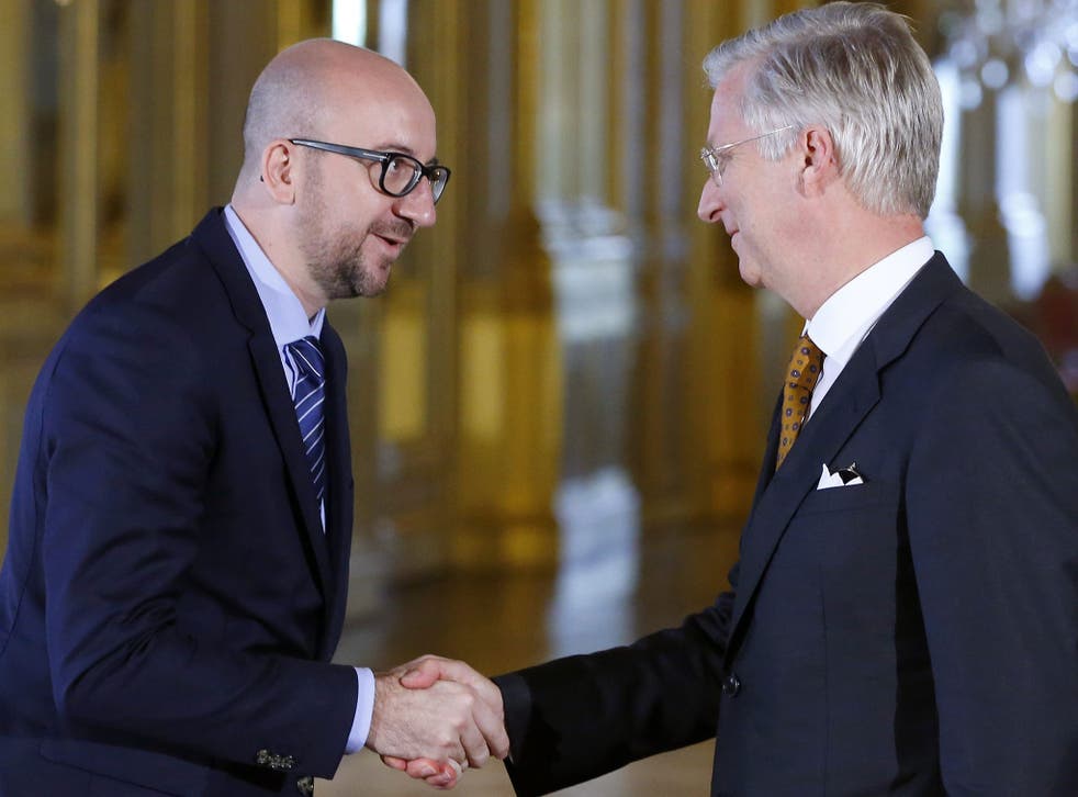 Belgium's new Prime Minister Charles Michel, left, shakes hands with King Philippe after a swearing-in ceremony at the Brussels Royal Palace