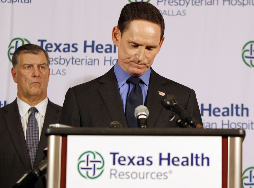 Dallas Mayor Mike Rawlings, left, looks on as Dallas County Judge Clay Jenkins speaks about a health care worker who contracted Ebola providing hospital care for Thomas Eric Duncan