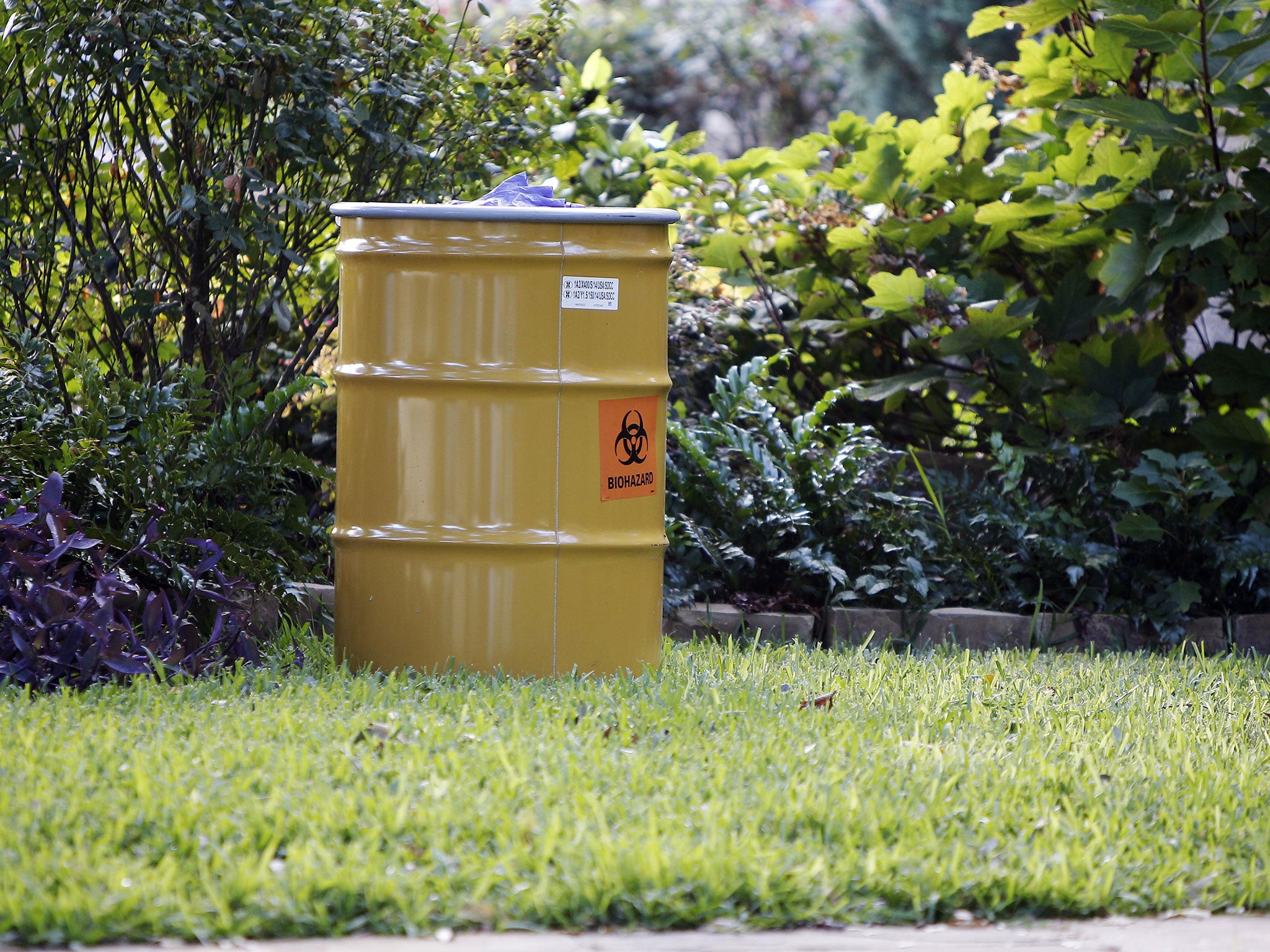 A barrel labeled biohazard is left on the front lawn of a healthcare worker's apartment after she contracted Ebola in Dallas, Texas on 12 October, 2014