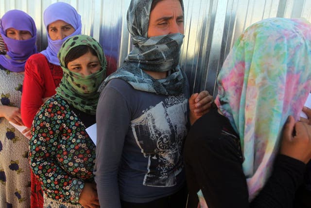 Yazidi women queue for food at the Bajid Kandala camp in Dohuk province, where they took refuge after fleeing the advancing Isis forces. Reports say more than 1,000 are still being held captive 