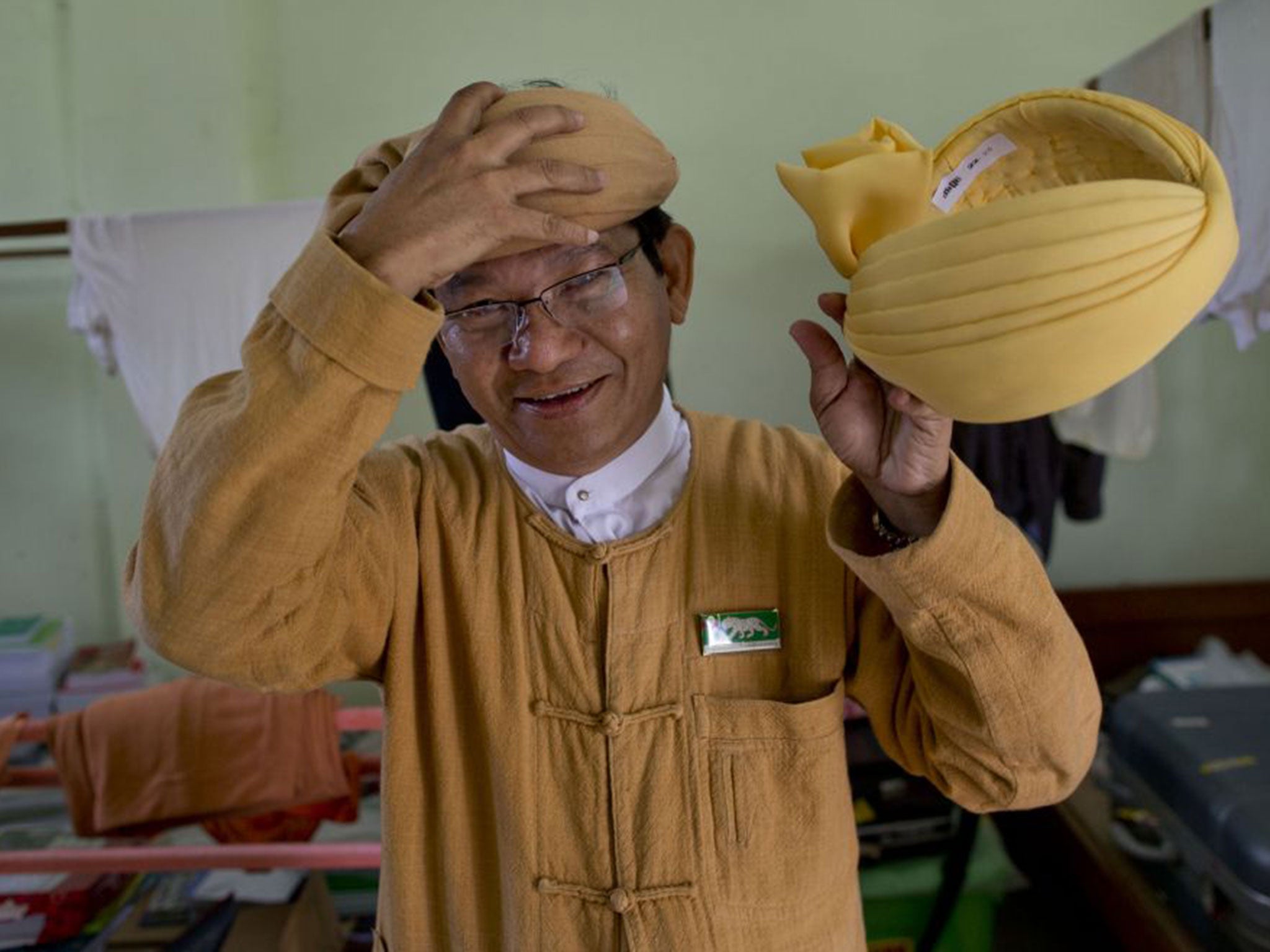 Hats off: Ye Tun, an ethnic Burman and a member of Myanmarís Lower House, dons a cotton hat while holding a silk one – just some of the head pieces seen in Parliament