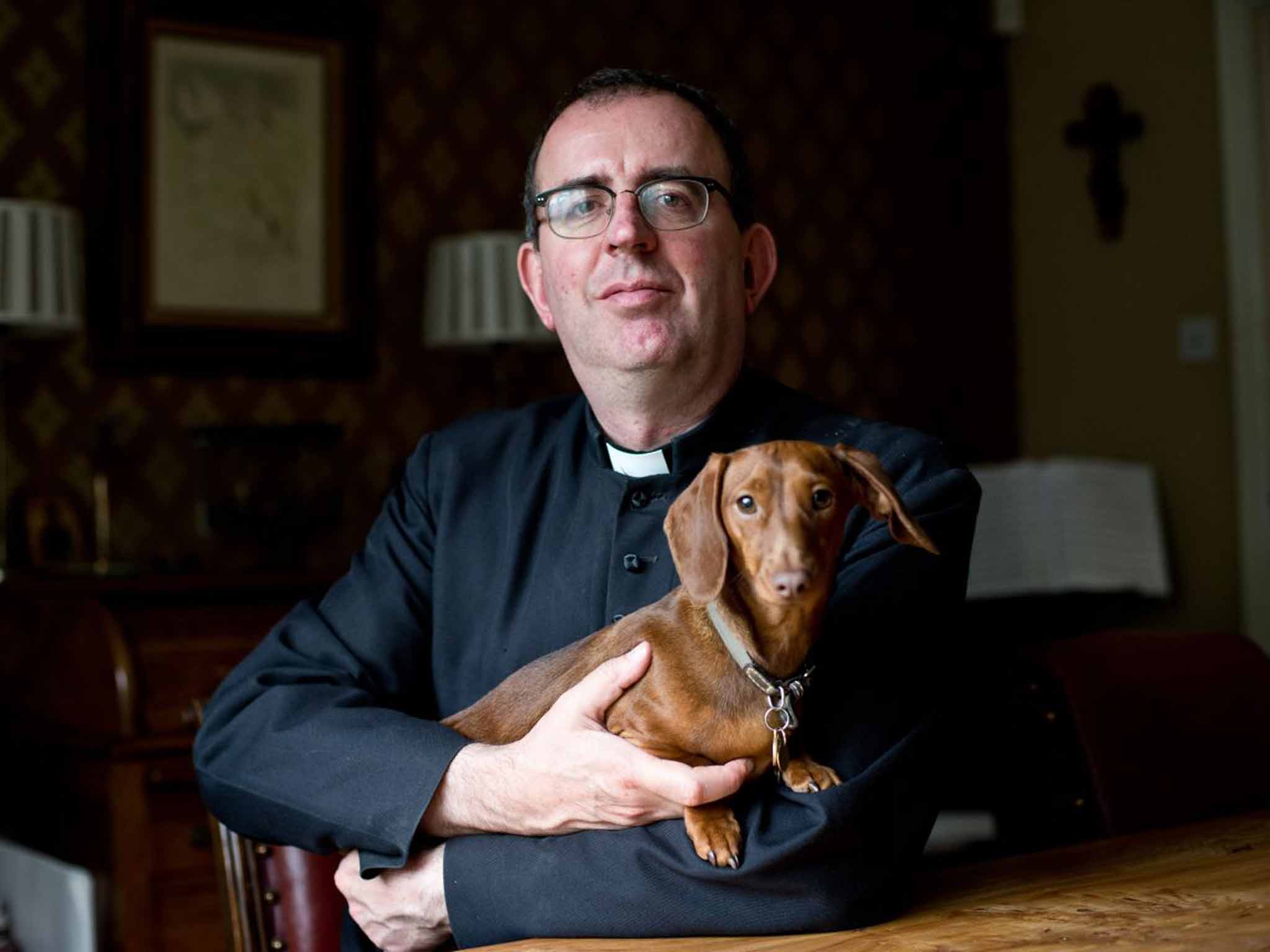 In dog we trust: Richard Coles with one of his pets at his Finedon vicarage