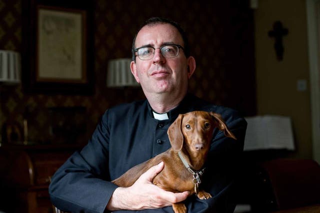 In dog we trust: Richard Coles with one of his pets at his Finedon vicarage 