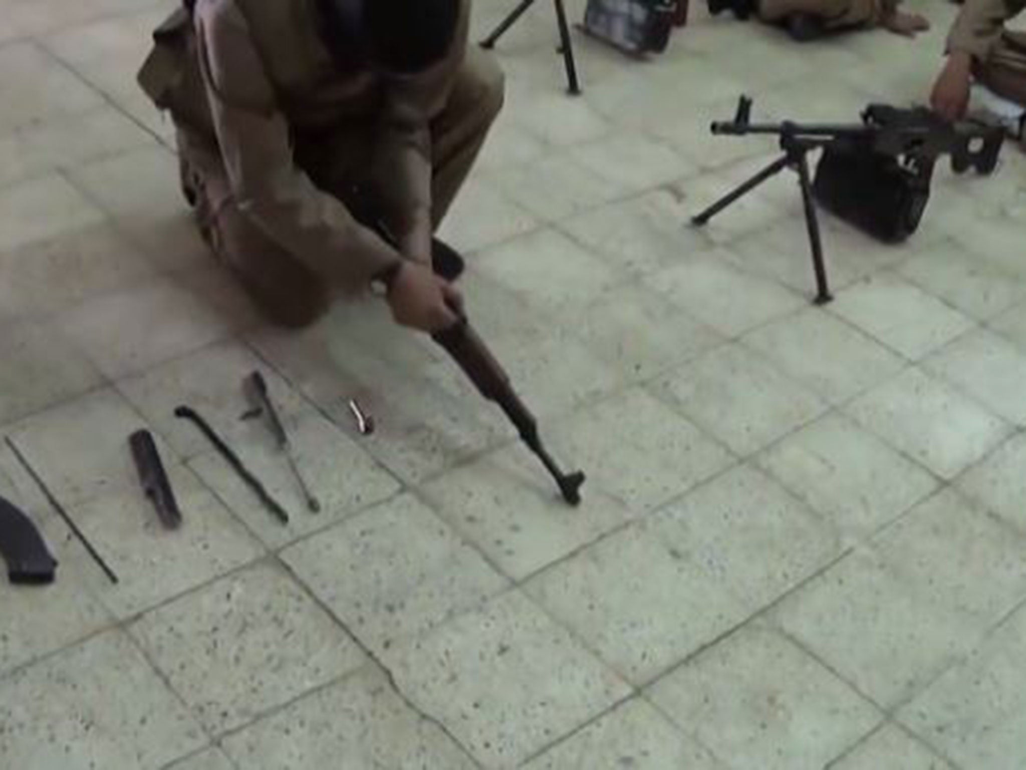 An Isis recruit takes apart a machinegun in a propaganda video purportedly filmed at a training camp in northern Iraq