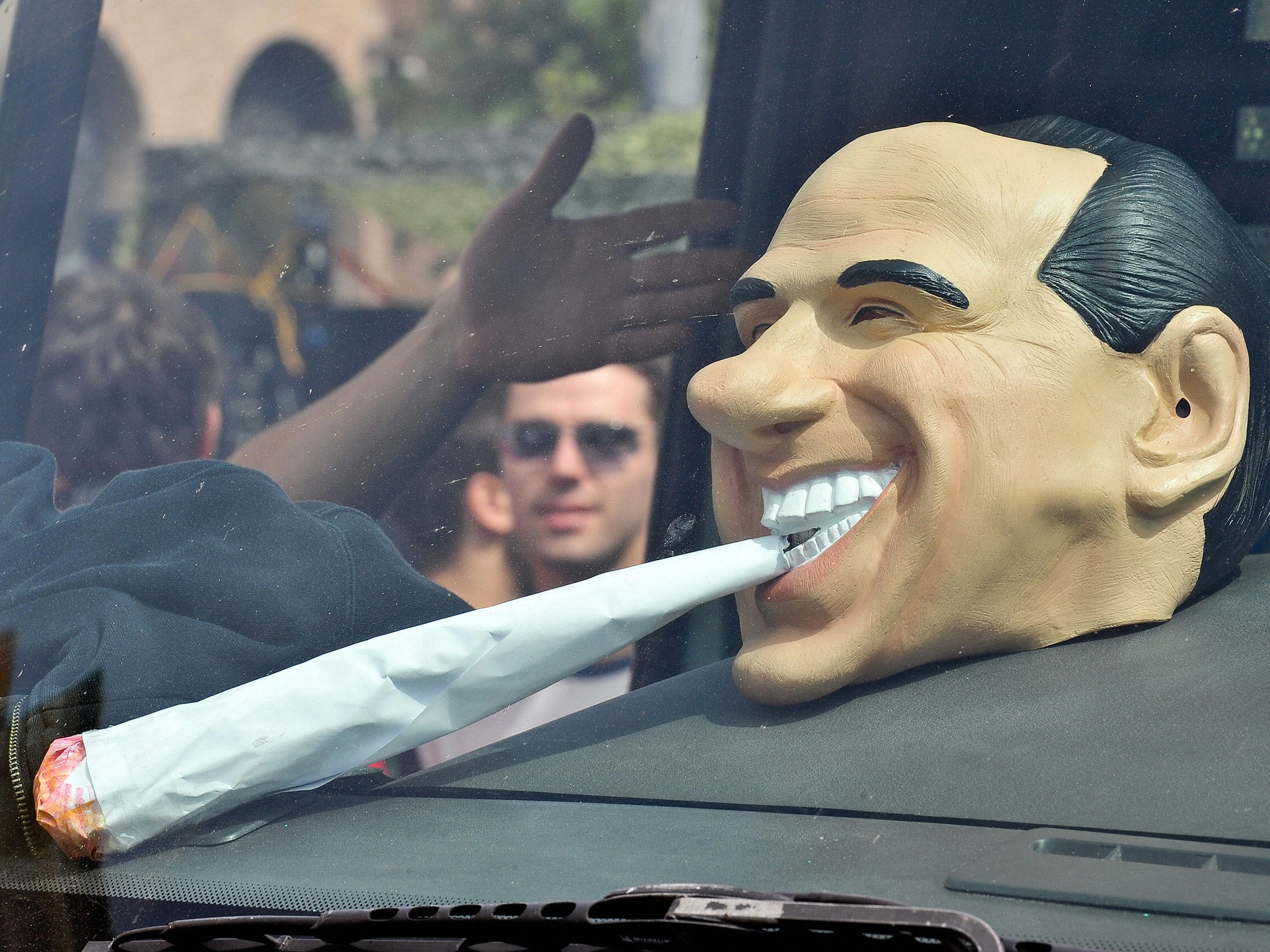 A mask of former Italian prime minister Silvio Berlusconi smoking a joint during the Million Marijuana March in Rome, 2009