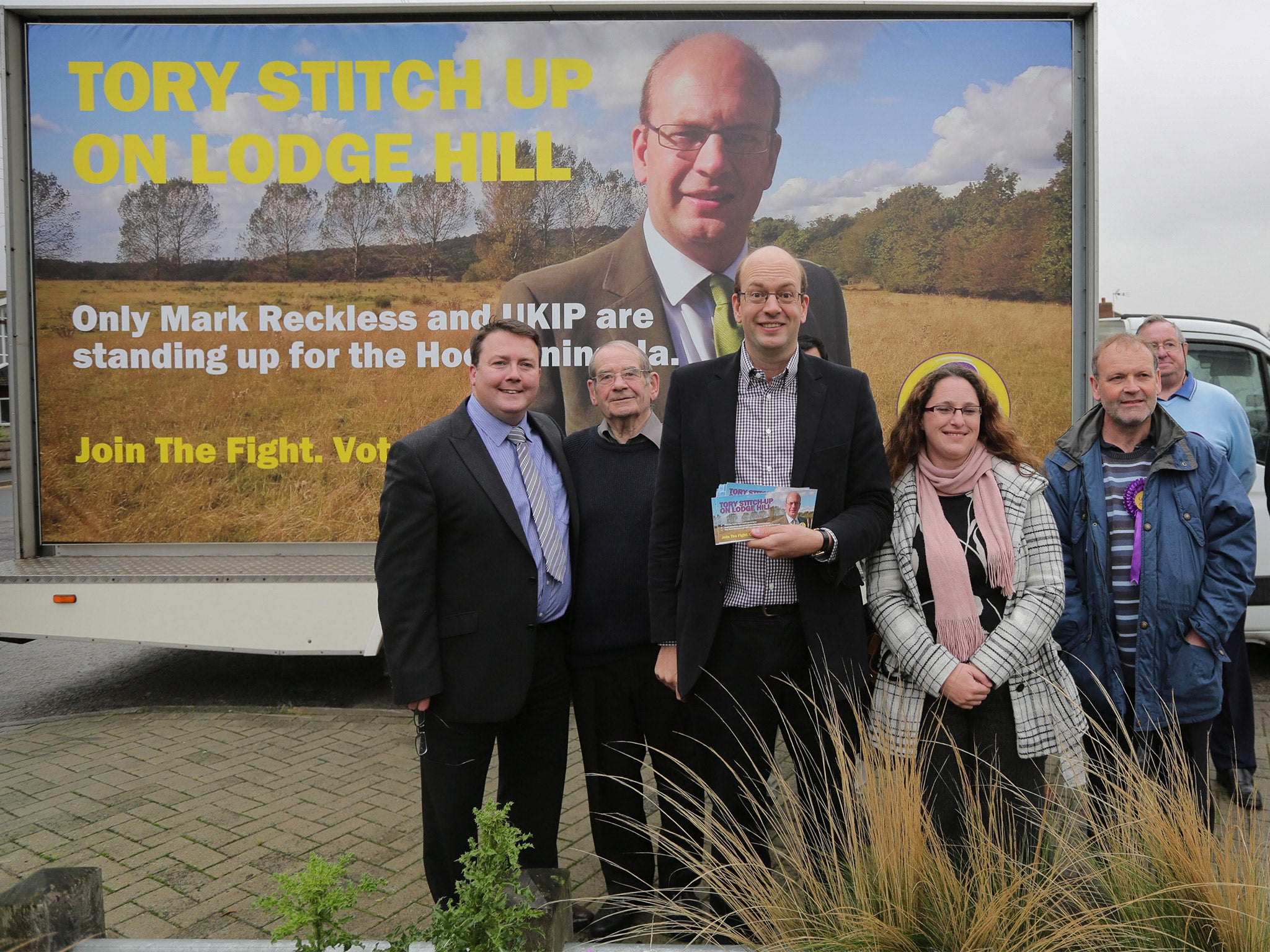Mark Reckless poses in front of a campaign poster whilst canvassing support in Hoo, Kent