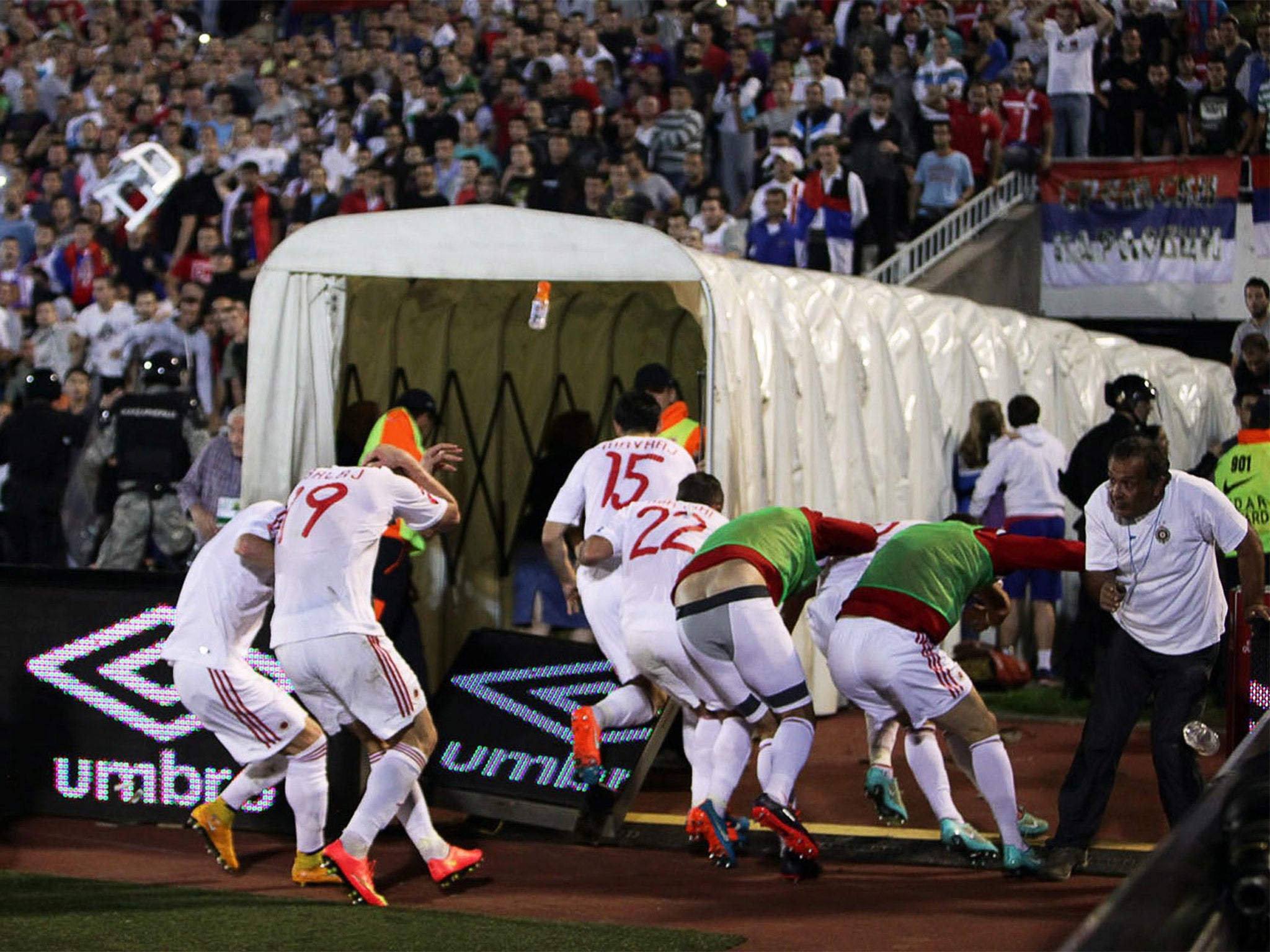 Albanian players take cover as they flee the pitch