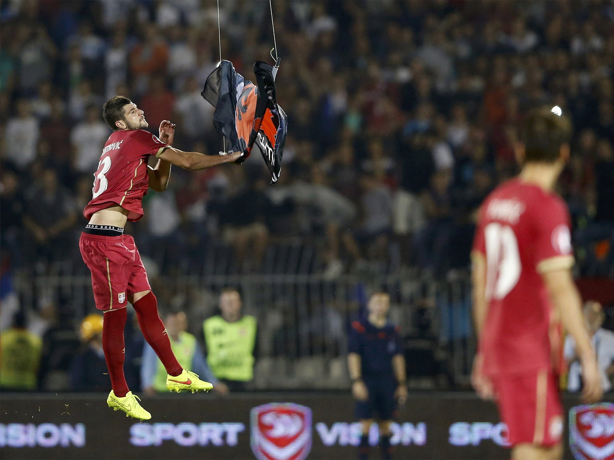 Serbian player Stefan Mitrovic pulls down the flag that was flown in by drone