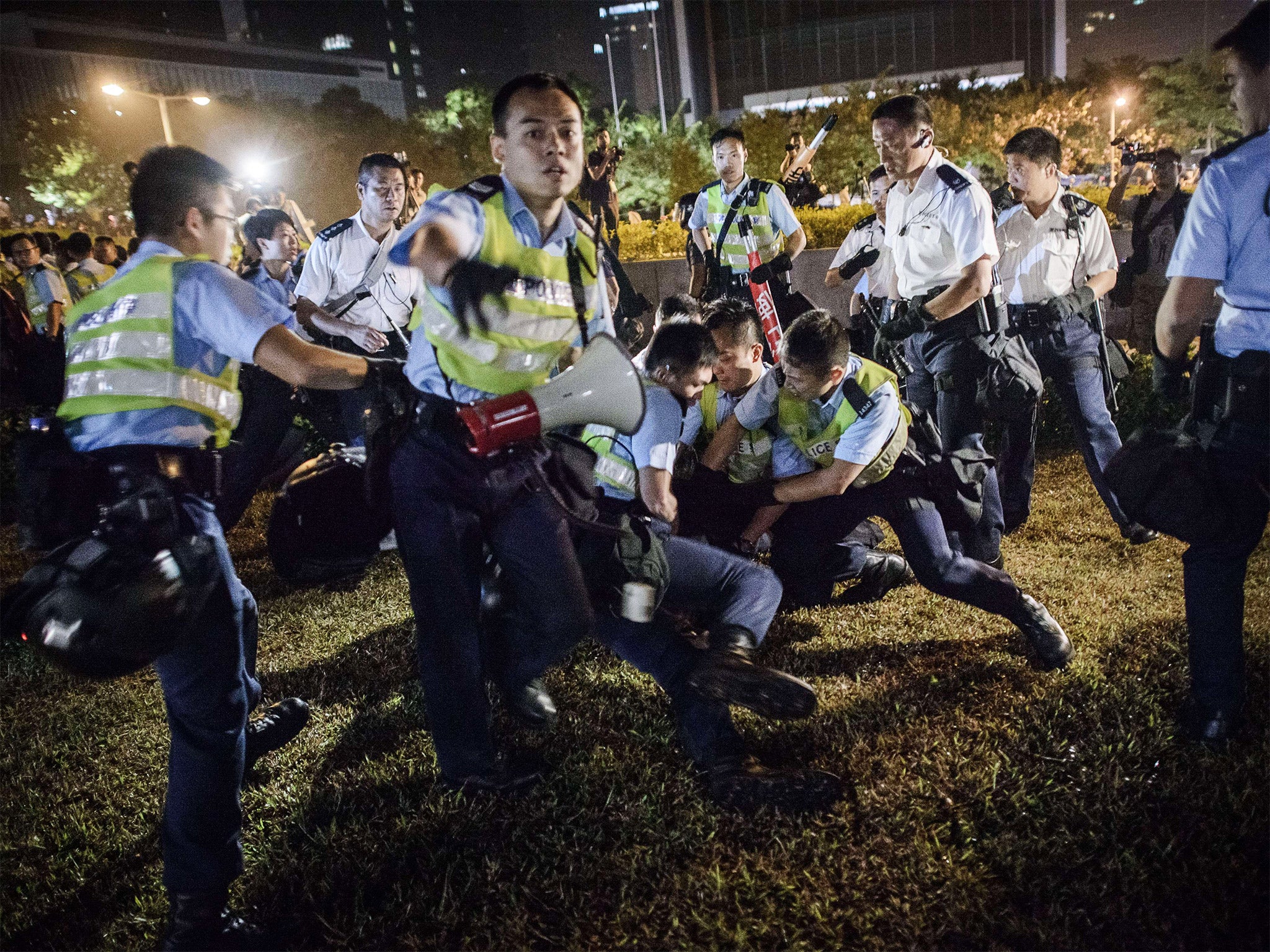 Police forces arrest pro-democracy protesters outside the central government offices in Hong Kong