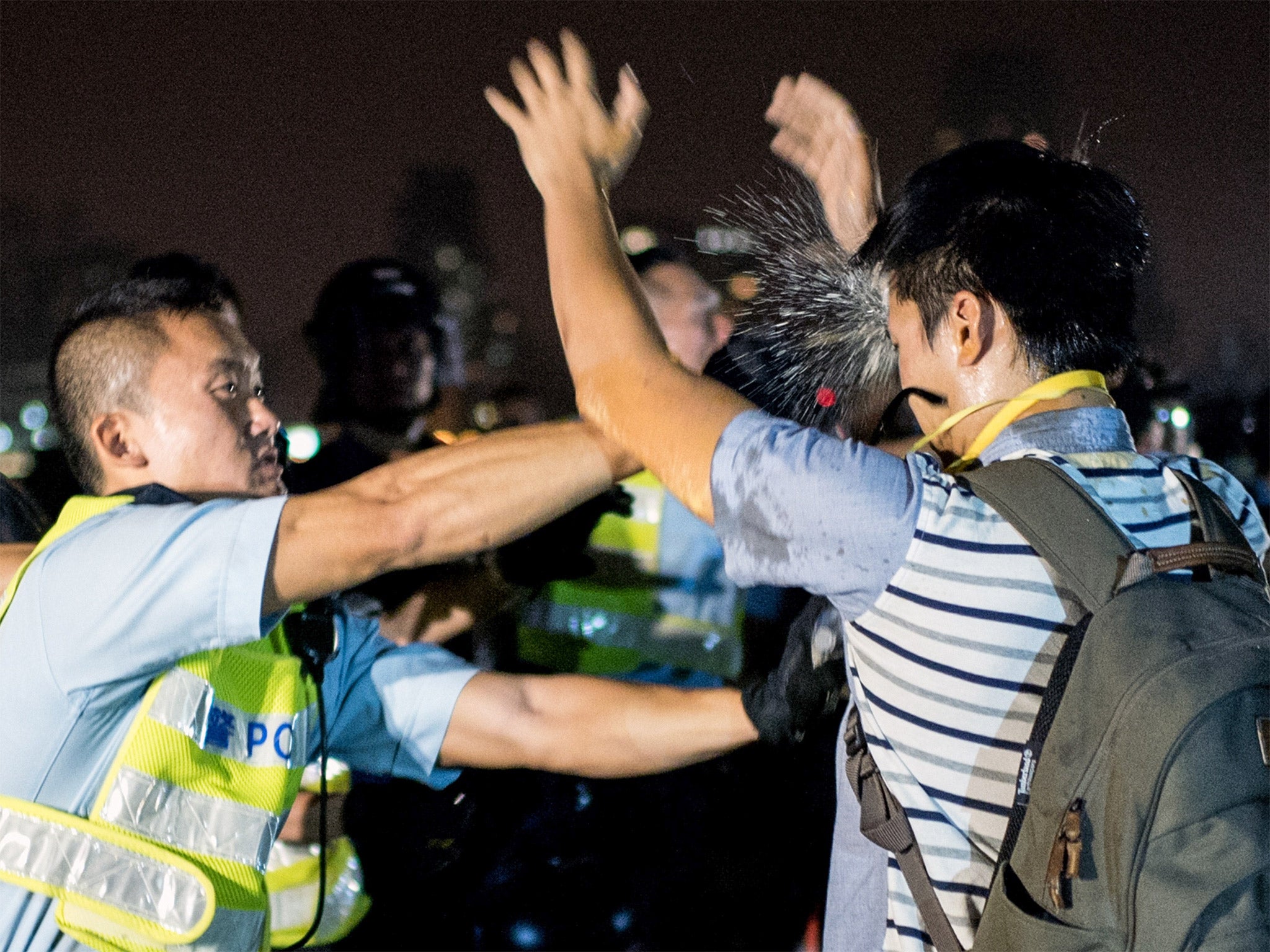 A policeman sprays an activist in the face with pepper spray as the authorities move to clear protesters from the central area
