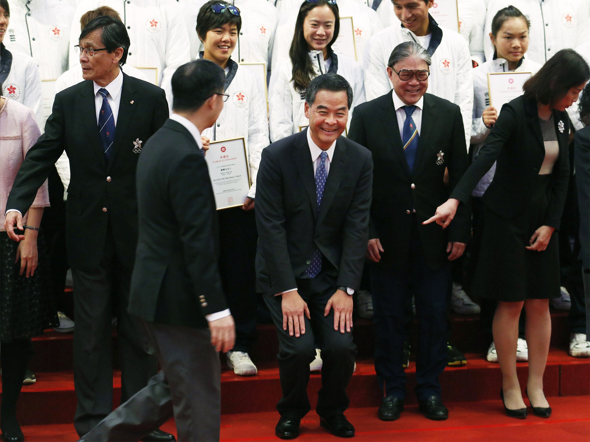 Hong Kong chief executive CY Leung (centre) tries to lighten the mood after the assault on a protester by police