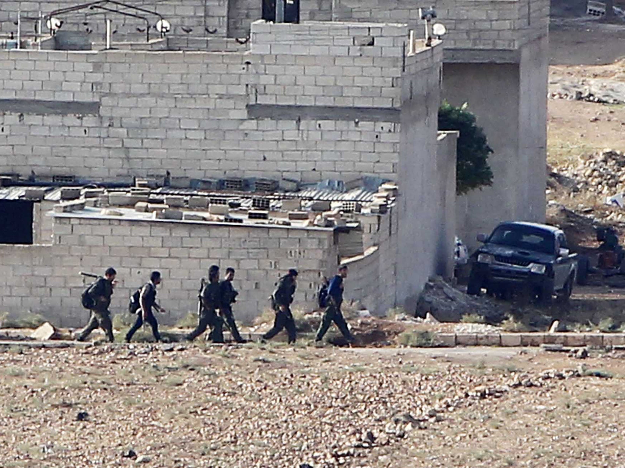 People's Protection Unit (YPG) fighters walk in Kobani