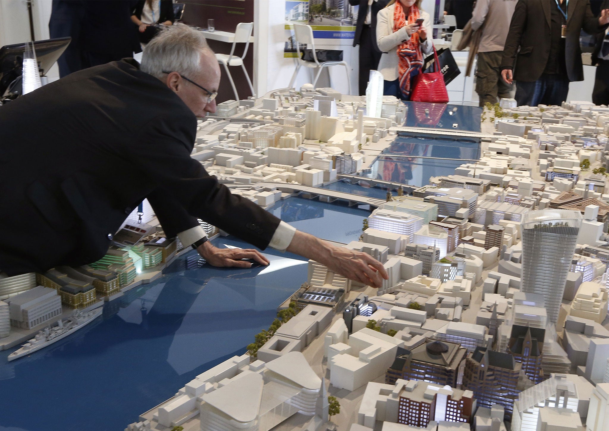 People look at a scale model of the city of London on March 11, 2014 in Cannes, southeastern France, during the MIPIM, an international real estate show for professionals