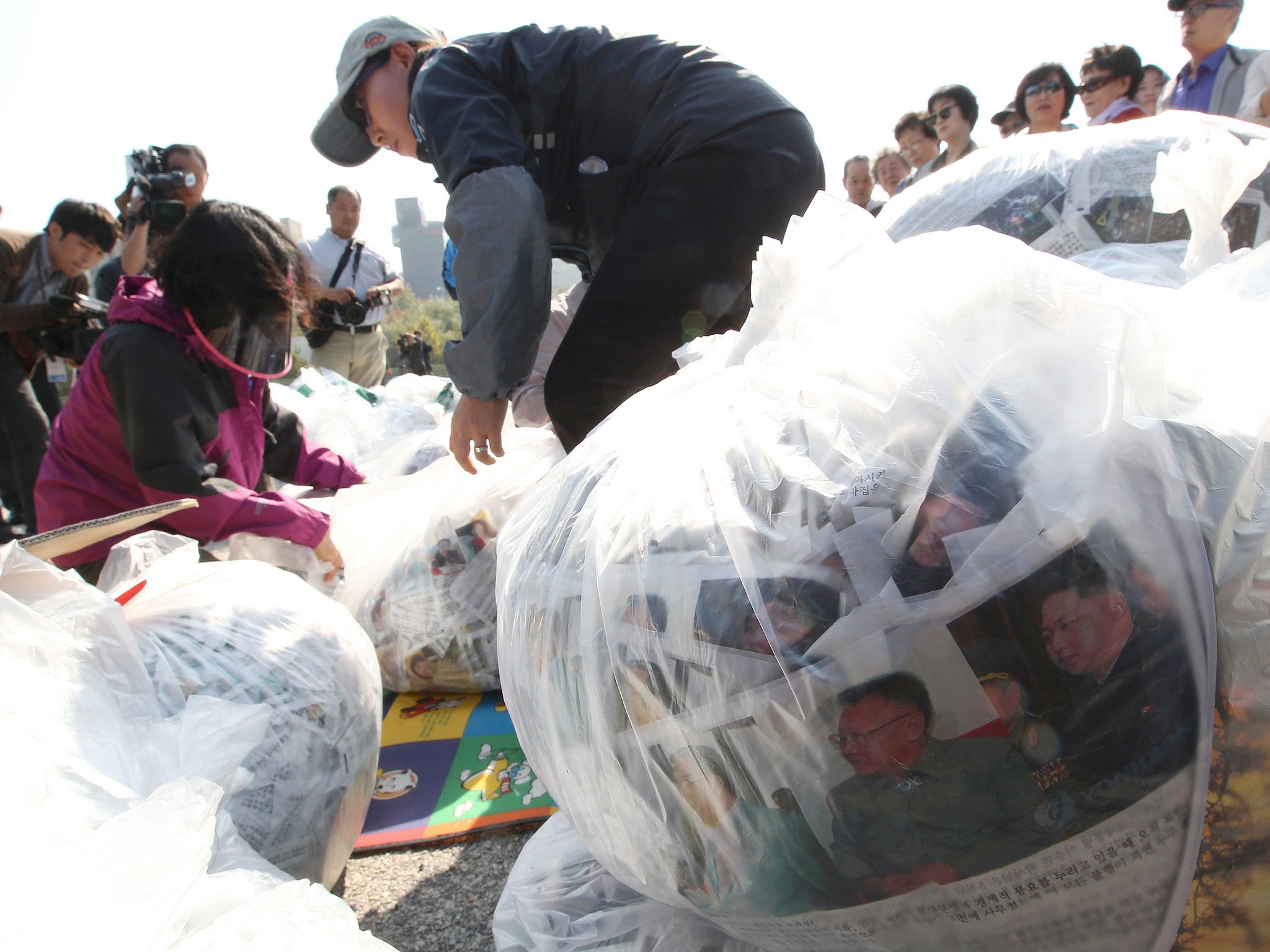 North Koran defectors prepare plastic bags containing leaflets condemning North Korean leader Kim Jong Un