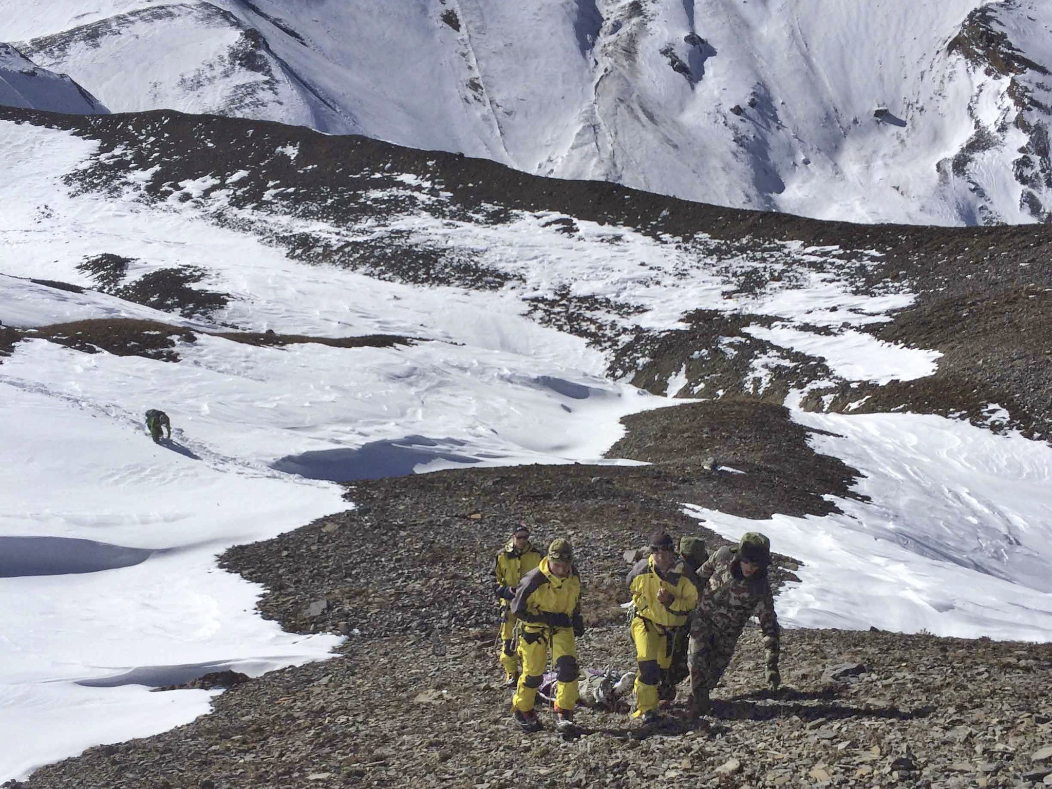 Rescue team members carry a victim of the avalanche