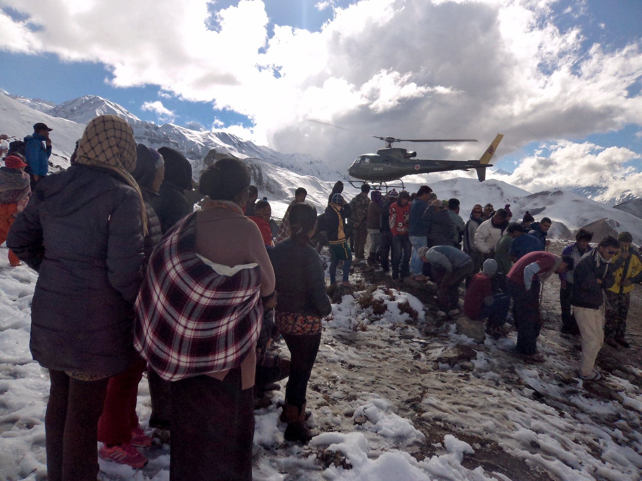 A Nepalese army helicopter rescues survivors of snow storms and avalanches which have killed at least 32 trekkers and guides on the Annapurna trail this week; scores of people are still missing