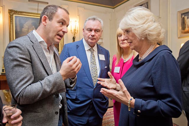 Camilla, Duchess of Cornwall, speaks with money saving expert Martin Lewis during her reception to mark International Credit Union Day at Clarence House
