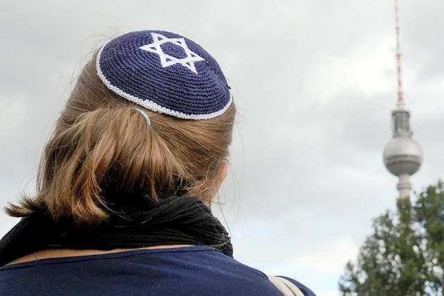A woman wears a kippah, the traditional Jewish headdress, as she takes part in a demonstration in Berlin