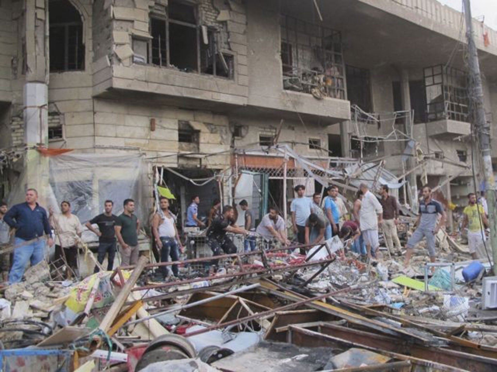People gather at the site of a car bomb attack in Baghdad, October 16,