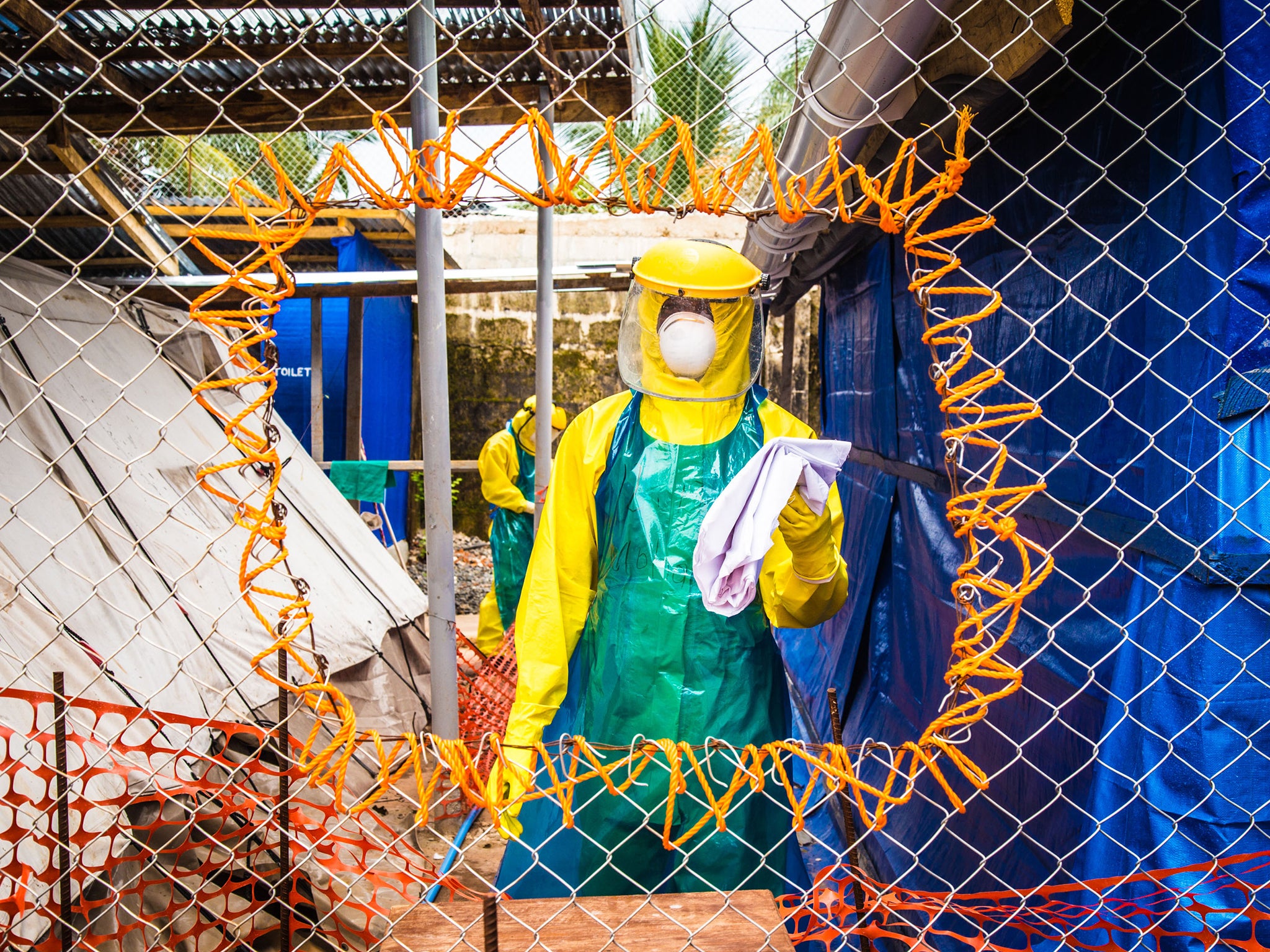 Healthcare workers in protective gear work at an Ebola treatment center in the west of Freetown, Sierra Leone