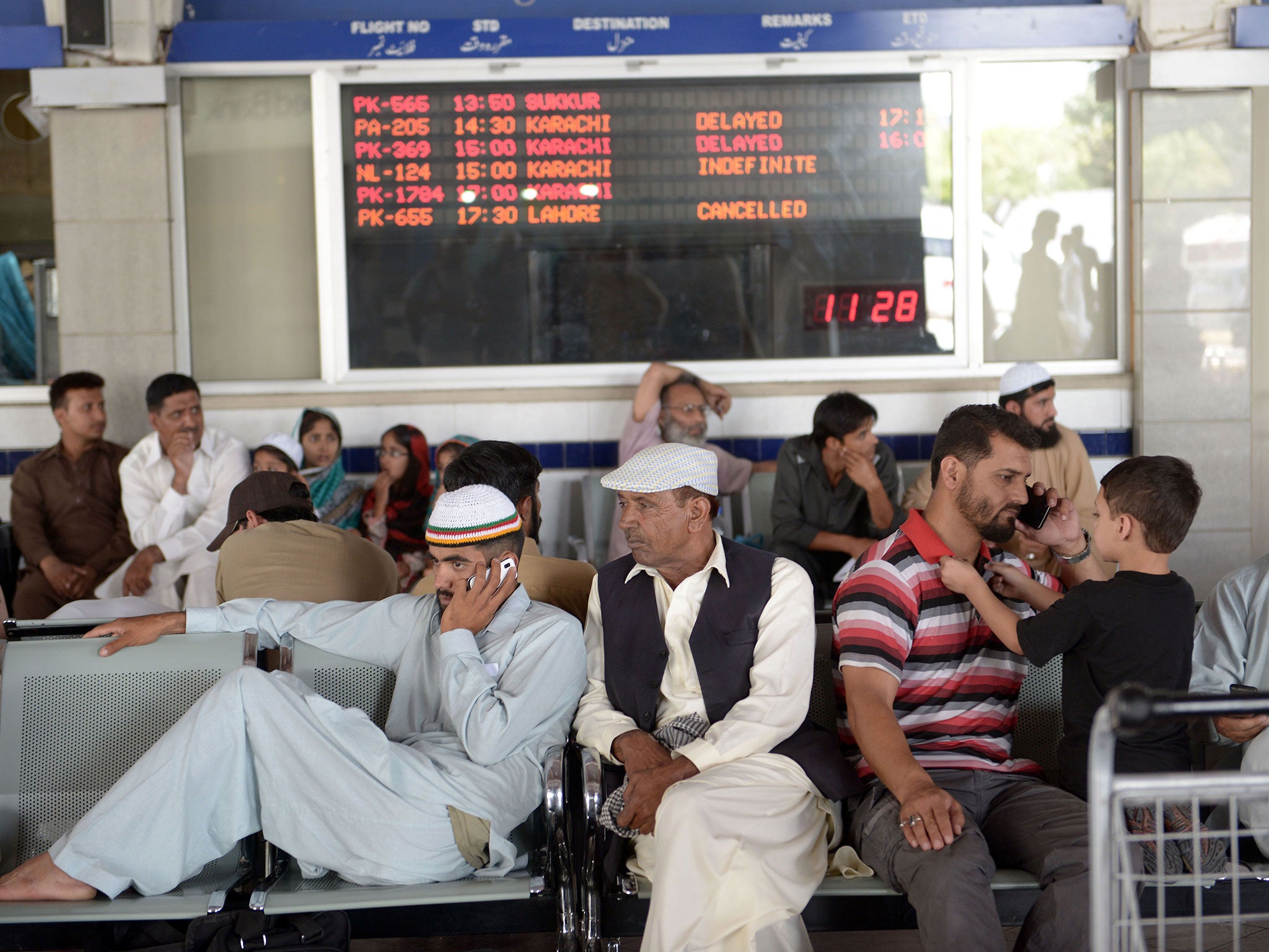 Passengers of Karachi-bound Pakistan International Airline (PIA) flights wait after delays at the Benazir Bhutto International Airport in Islamabad on June 9, 2014