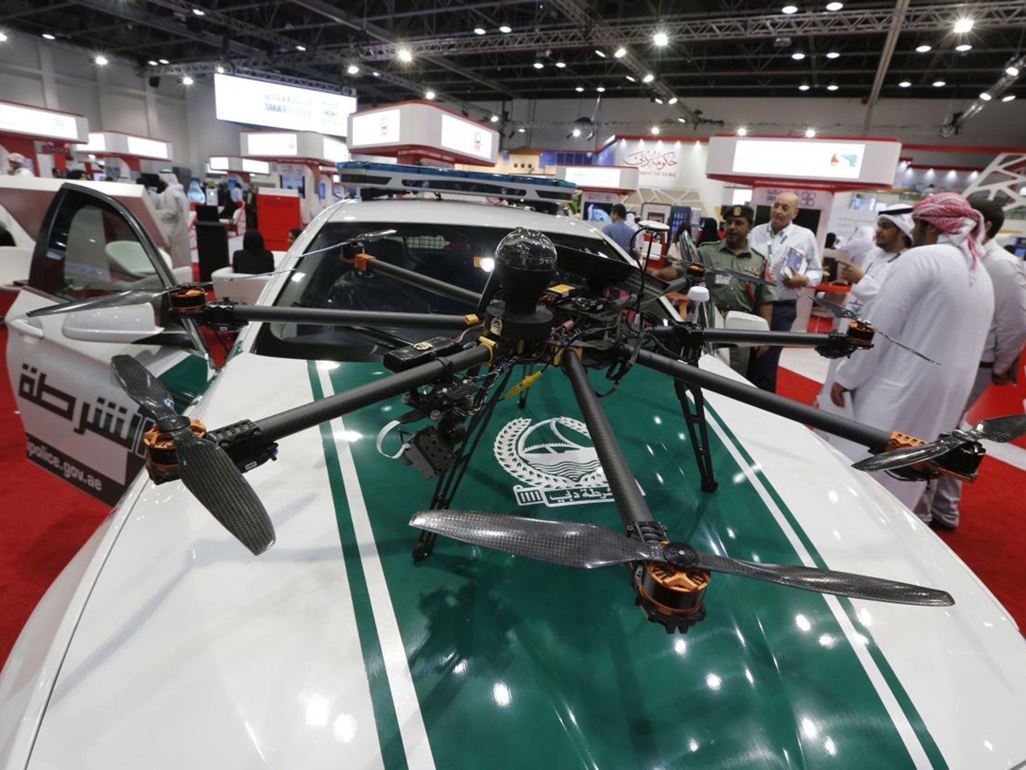 Visitors look at a drone equipped with cameras on a police car at the Gitex Technology week in Dubai