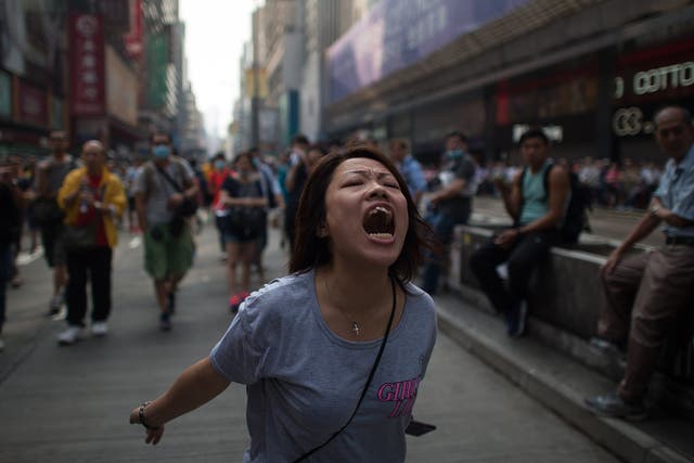 A pro-democracy protester shouts towards police after efforts to clear them from an area they were occupying in the Mong Kok shopping district of Hong Kong failed