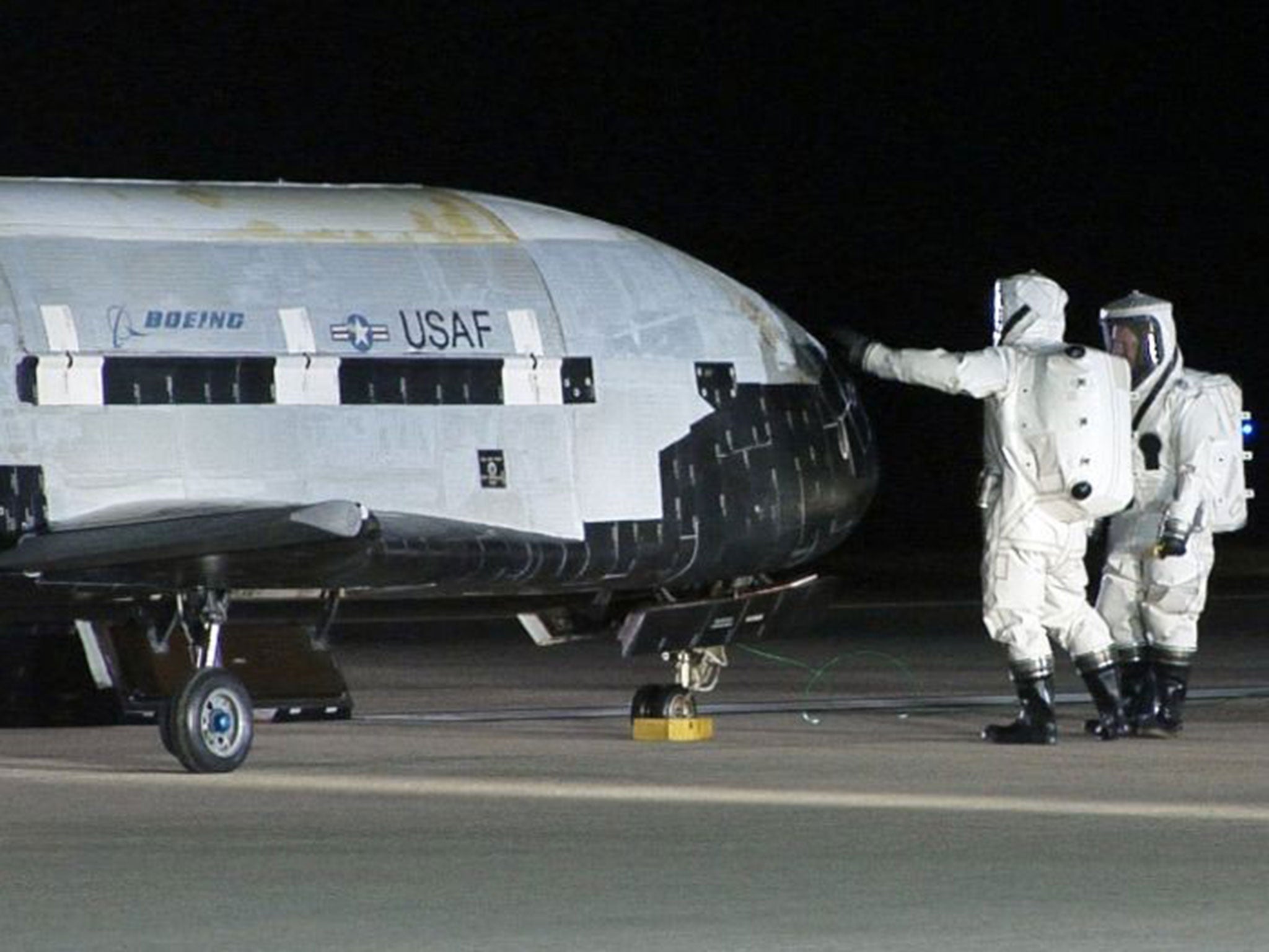 Technicians examining the X-37B unmanned spaceplane at Vandenberg Air Force Base, California