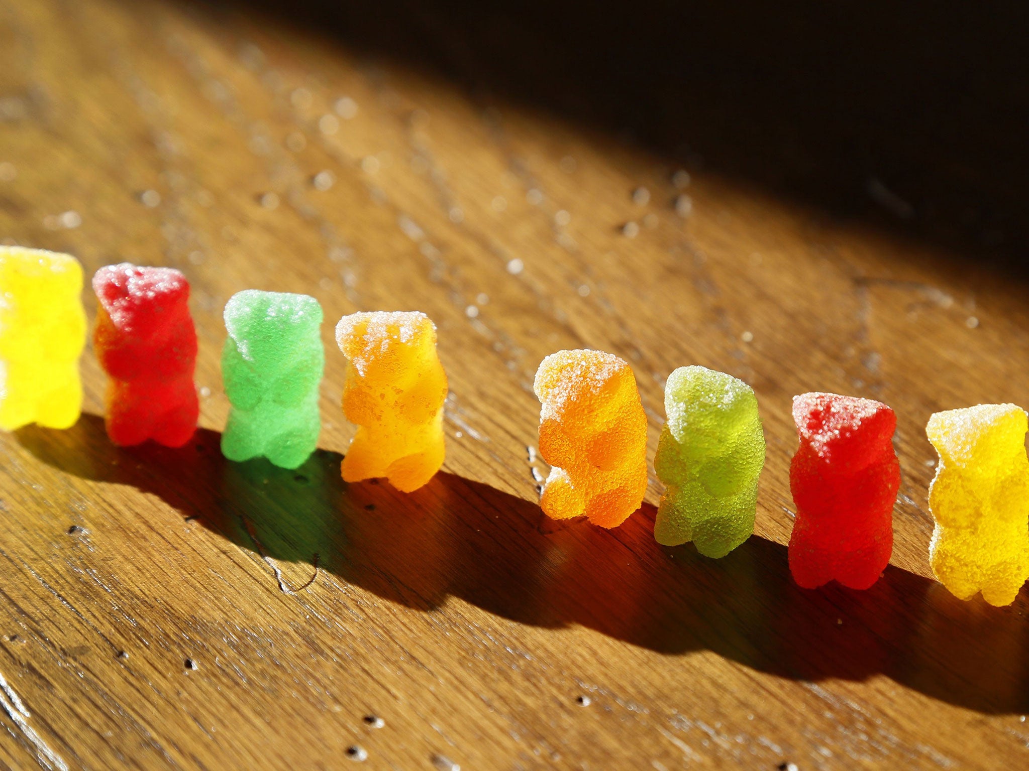 Marijuana-infused sour gummy bear candies (R) are shown next to regular ones (L)