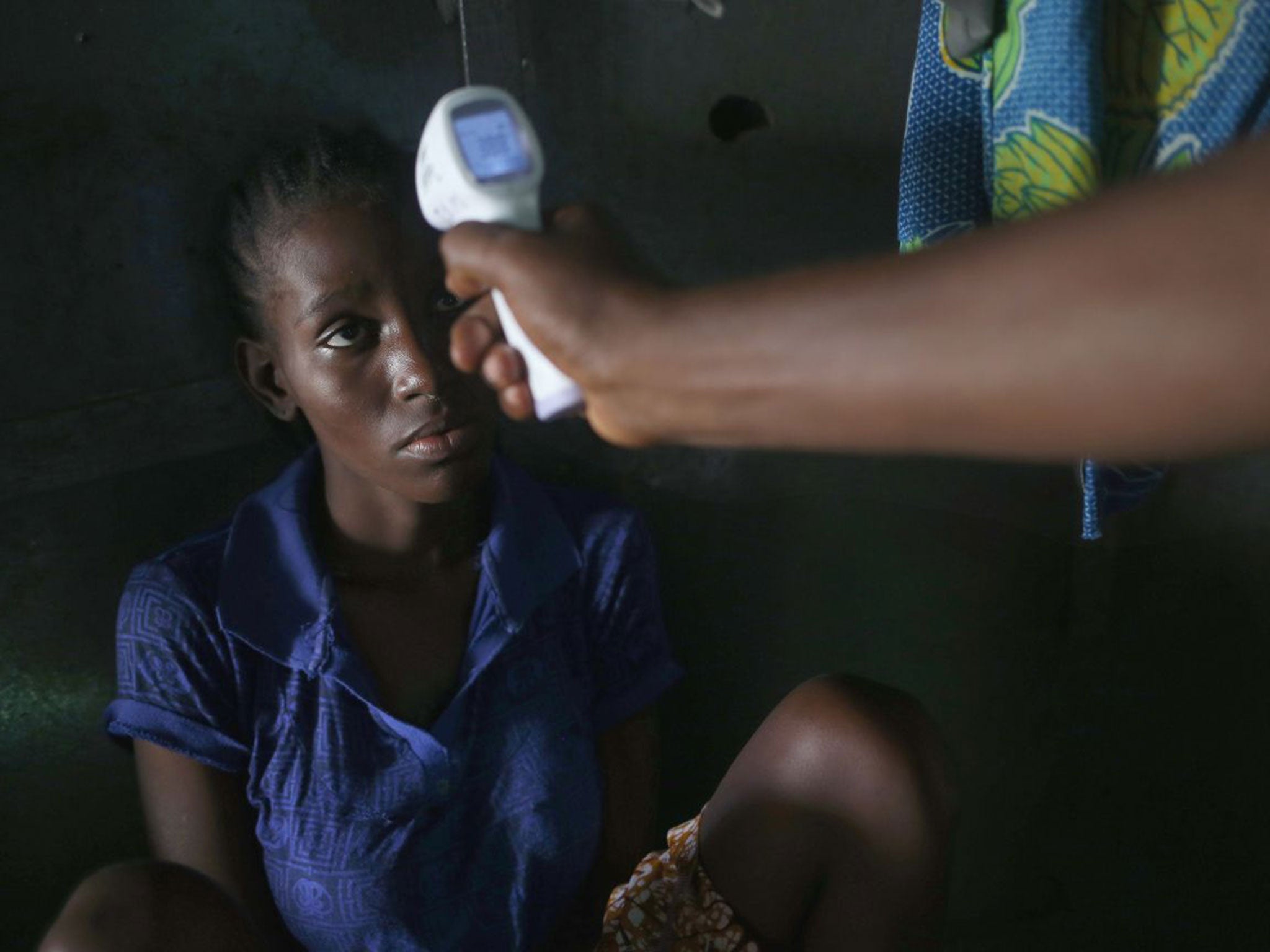 Jessica Sompon, 17, has her temperature taken on Friday in Monrovia, Liberia, after developing a fever. A relative had died from Ebola the day before