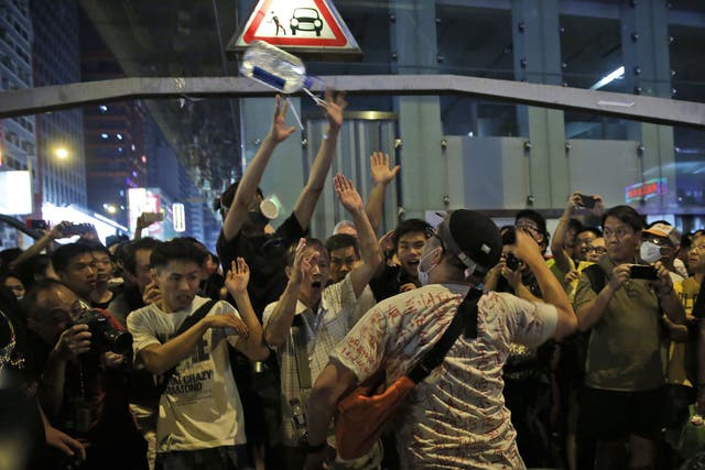 An anti-occupation protester throws a bottle of water at the crowd in the occupied area in the Mong Kok district of Hong Kong