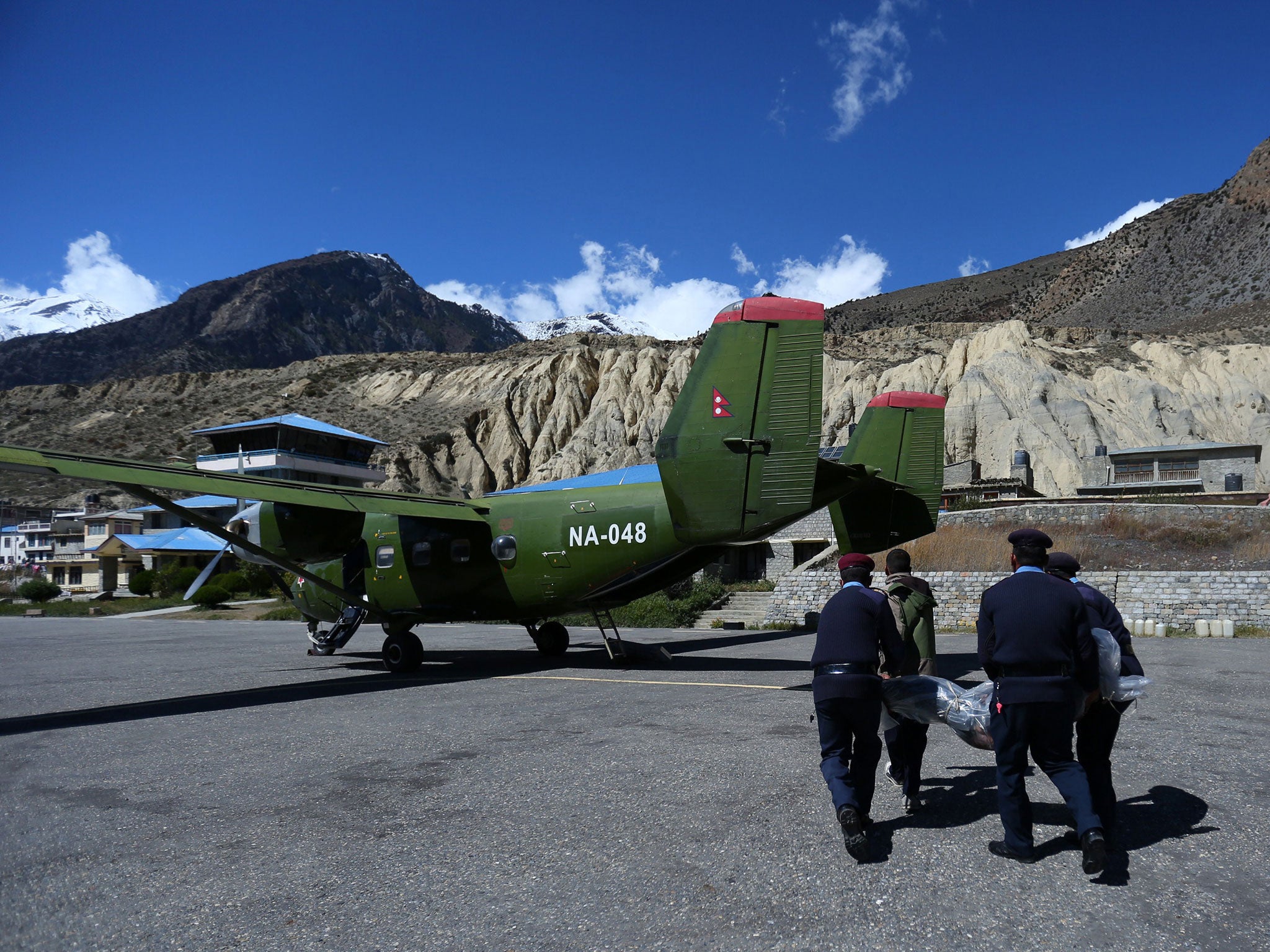 Police move the bodies of trekkers killed in a blizzard and avalanche to a transport plane in Jomsom, Nepal