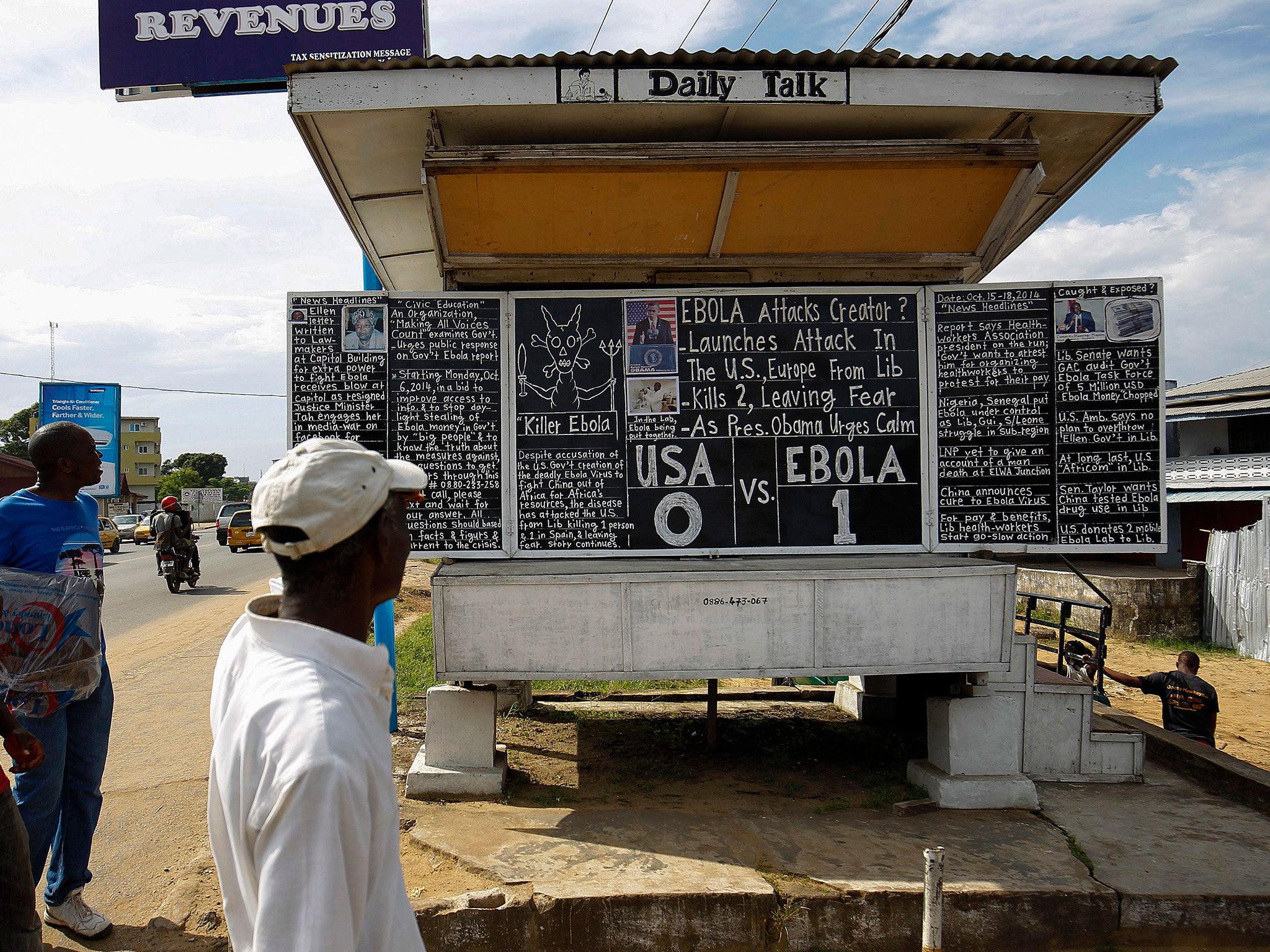 Liberians read a daily Ebola noticeboard in Monrovia