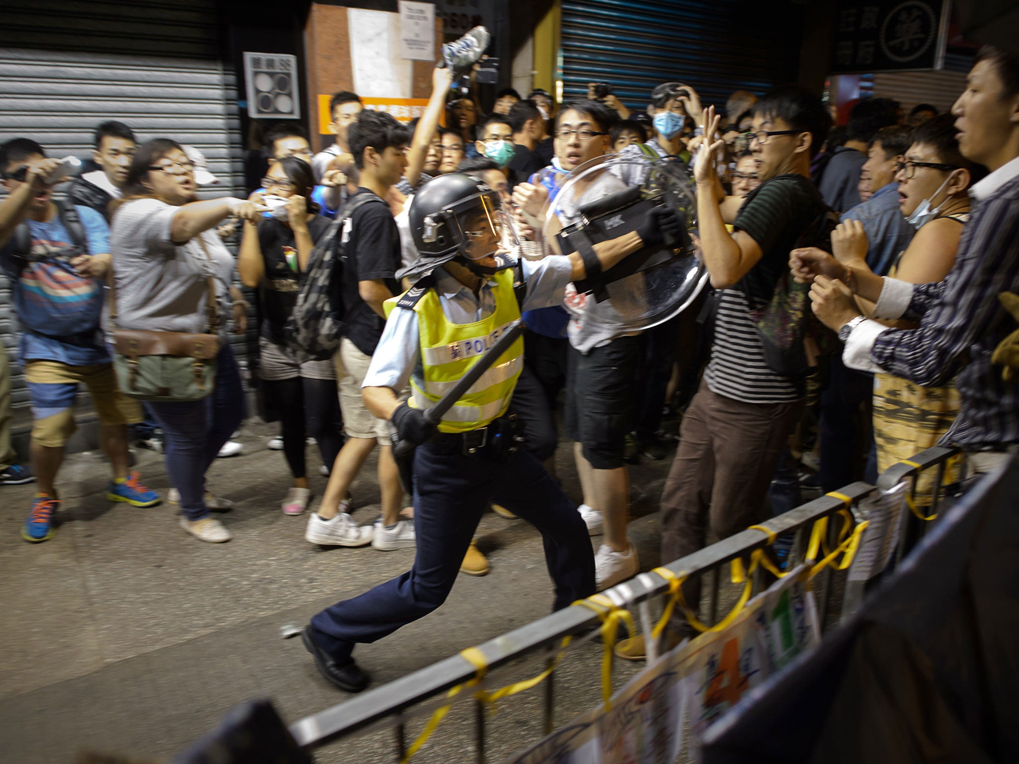 A policeman confronts protesters in the Mong Kok shopping district of Hong Kong