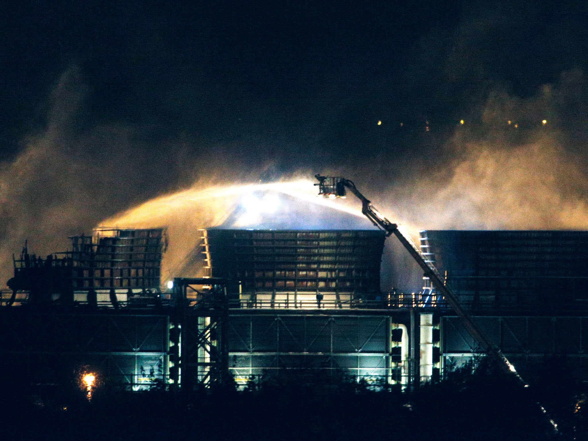 Fire crews spray water at the scene of a fire at Didcot B Power Station in Oxfordshire