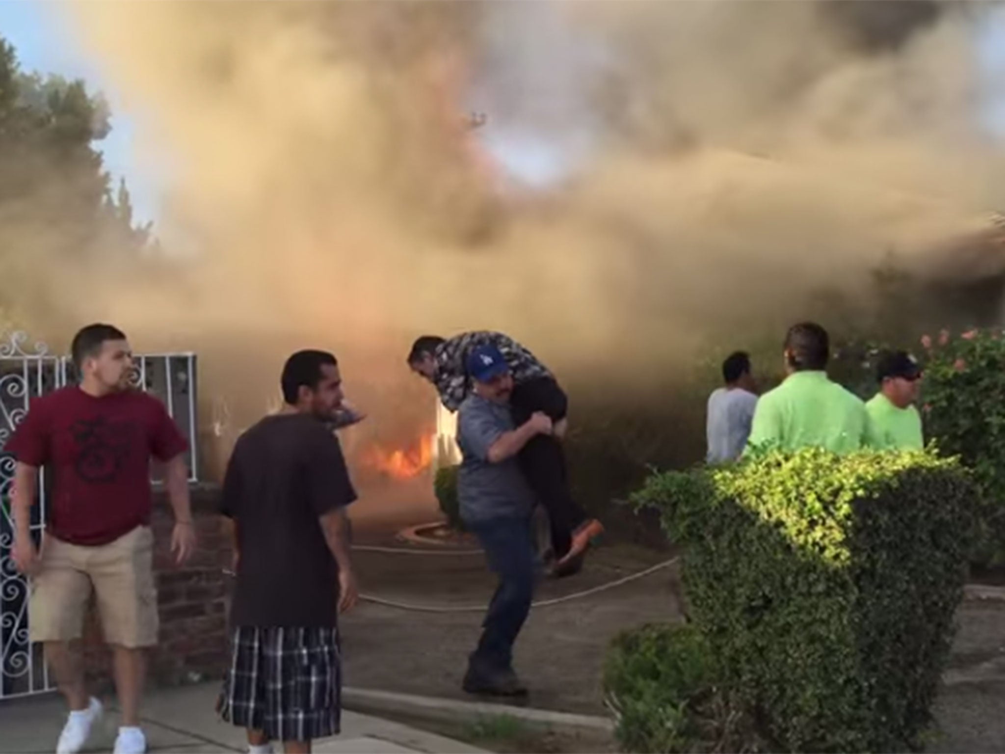 Footage shot by a passerby shows the moment an ill man was carried out of his burning home by a complete stranger.