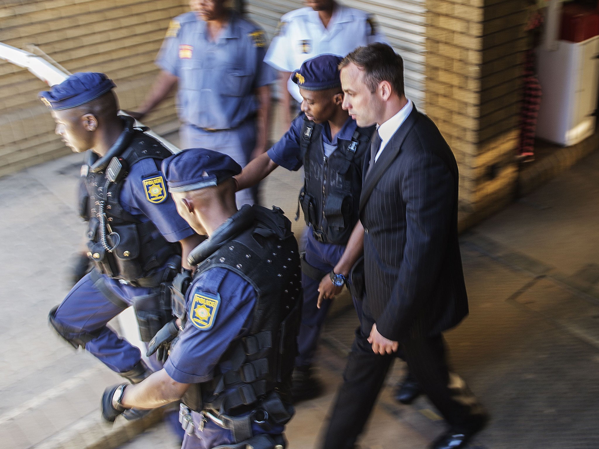 Oscar Pistorius is escorted by south African policemen to a police vehicle to transported to prison at the High Court in Pretoria