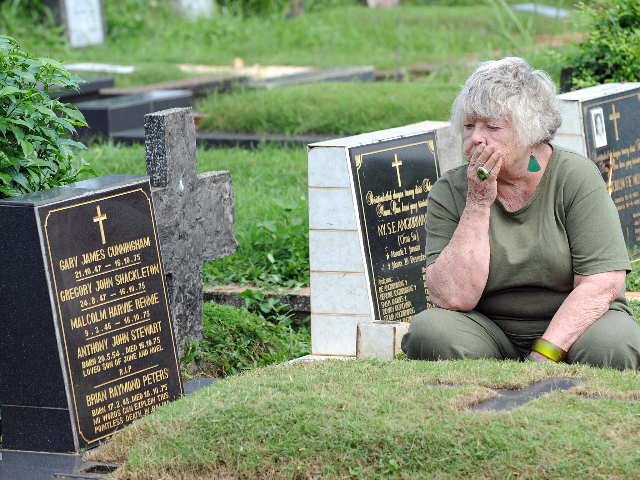 Shirley Shackleton, wife of late journalist Gregory Shackleton, sits next to the grave of the 'Balibo Five' in Jakarta, in 2010