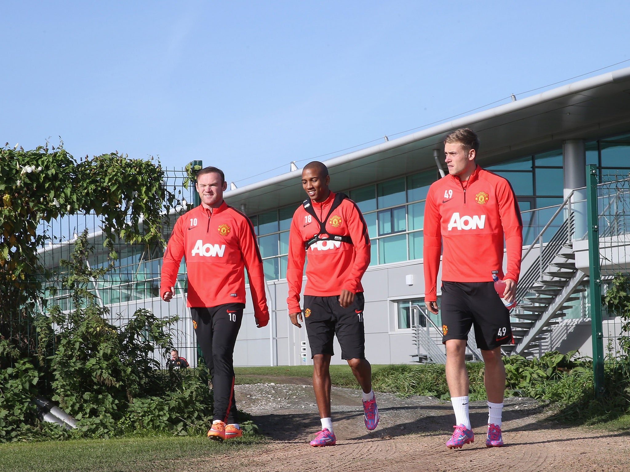 Wayne Rooney, Ashley Young and James Wilson emerge from the Aon Training Complex